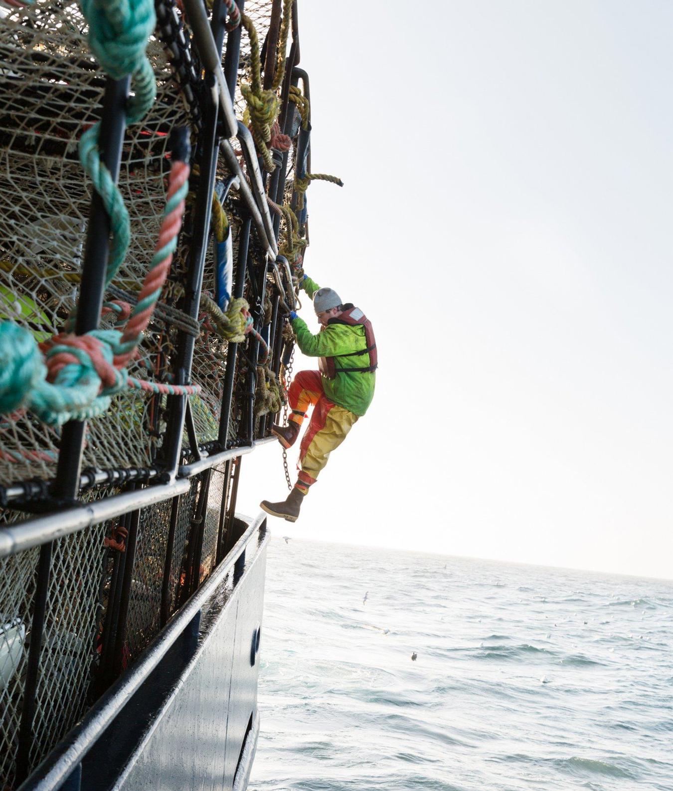 Rybář šplhající na loď